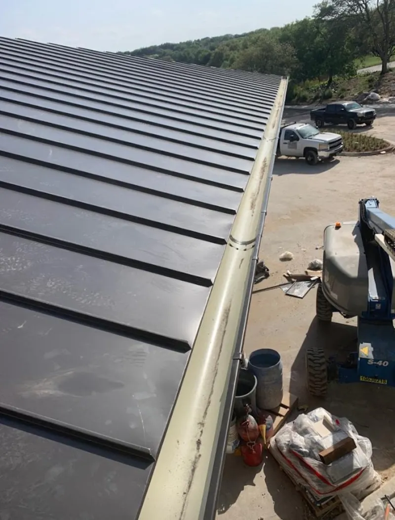 Standing seam panel and gutter detail on a metal roofing jobsite in Verona